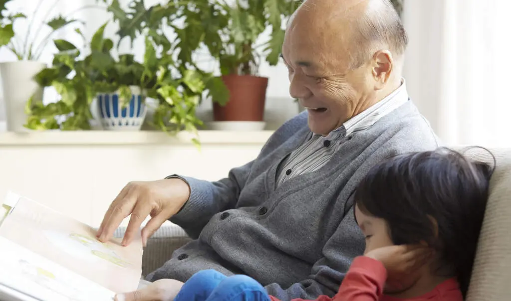 Mystellathreegenerationsfamilywithpremiumbooks | my stellaマイステラブログ|子どもの好きが育つヒントと親子の時間 祖父母、親、子どもの3世代家族が絵本を囲む温かな様子と、高級感あるギフトボックスに入ったMY STELLAの2種類のパーソナライズ絵本