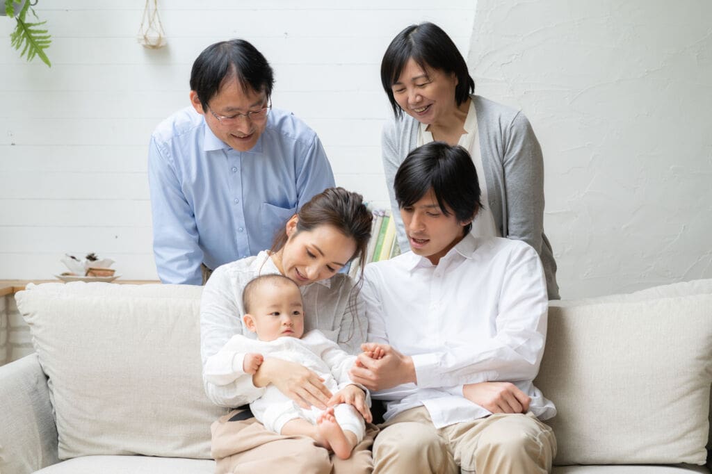 家族に囲まれた1歳の赤ちゃん | my stellaマイステラブログ|子どもの好きが育つヒントと親子の時間 両親と祖父母に囲まれて笑顔を向ける、1歳の赤ちゃん