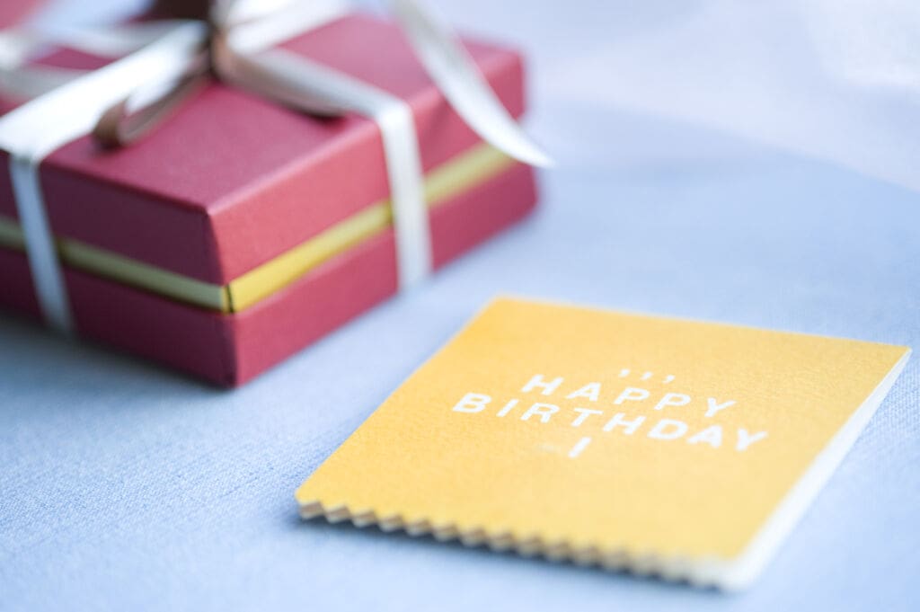 バースデーカードとギフトボックス | my stellaマイステラブログ|子どもの好きが育つヒントと親子の時間 HAPPY BIRTHDAYのカードと赤いリボン付きのギフトボックスの写真